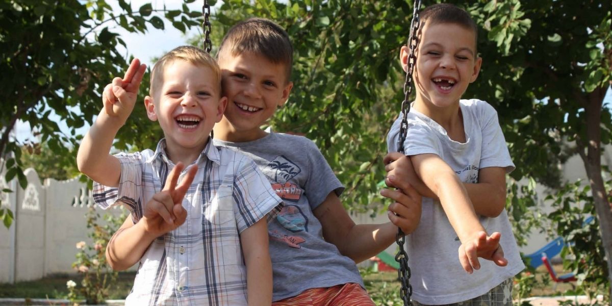 Three Moldovan boys on a swing