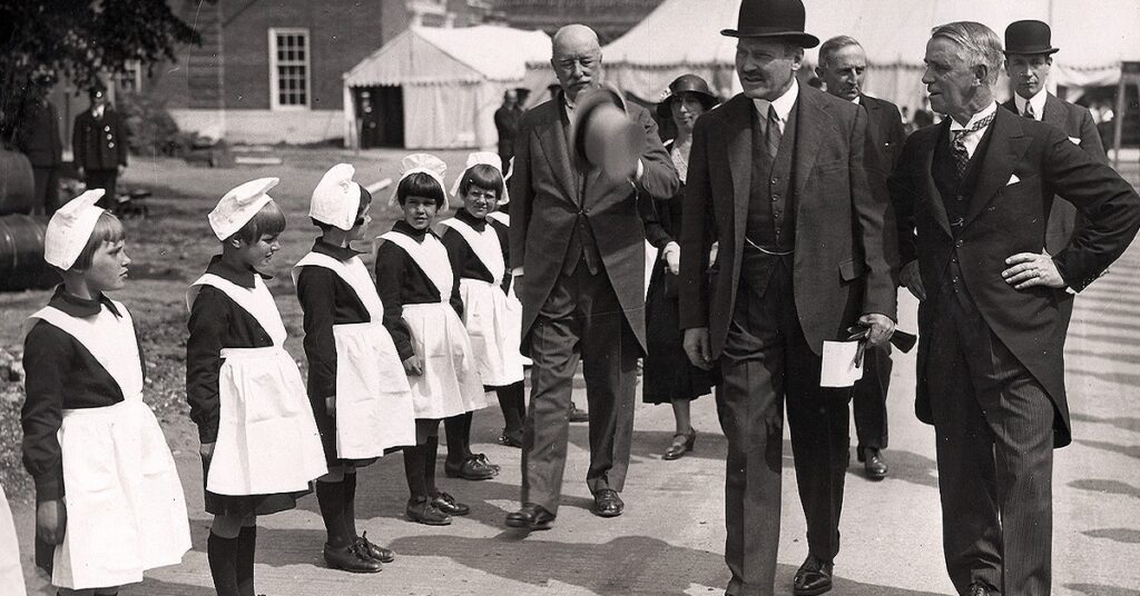 Foundlings lined up for inspection as a group of adults walk past them