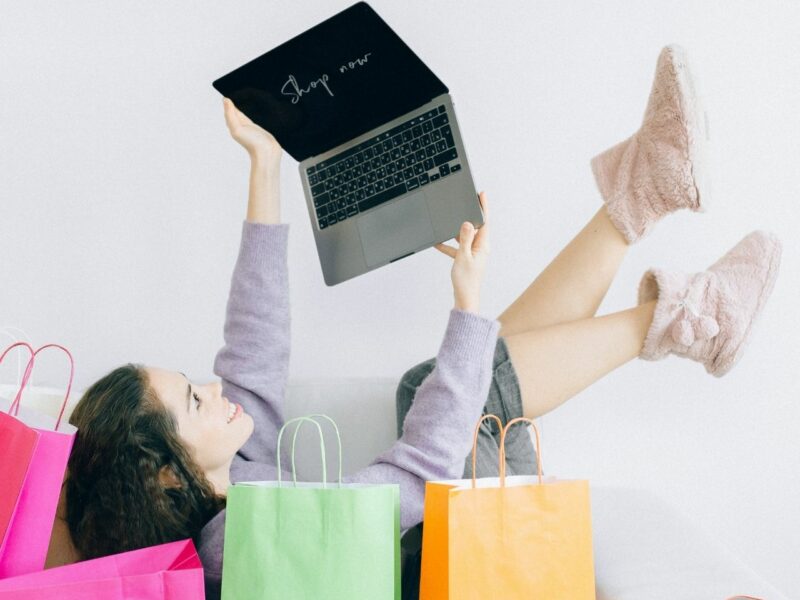 A woman with lots of shopping bags and a laptop