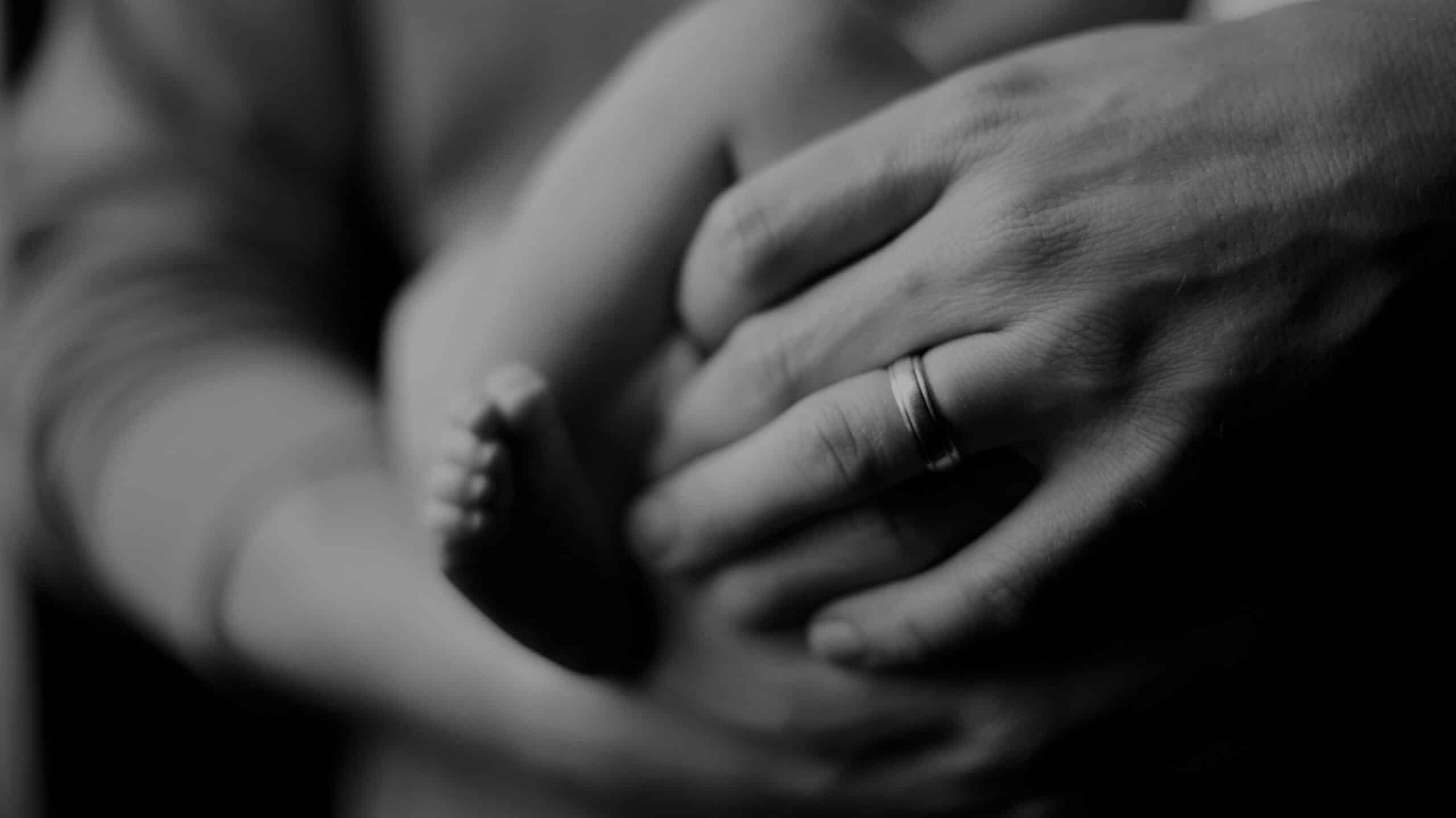 A parent holds their baby in their arms.