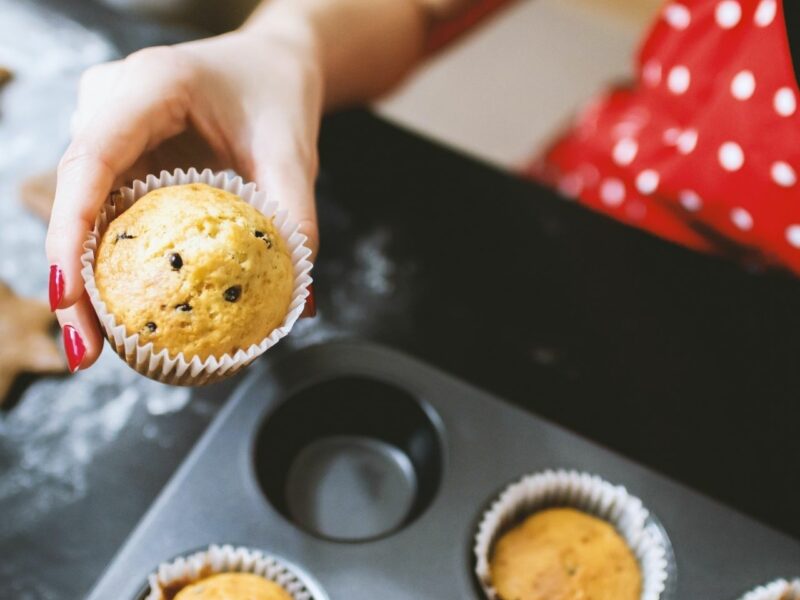 A woman's hand holding a cupcake for a tea party