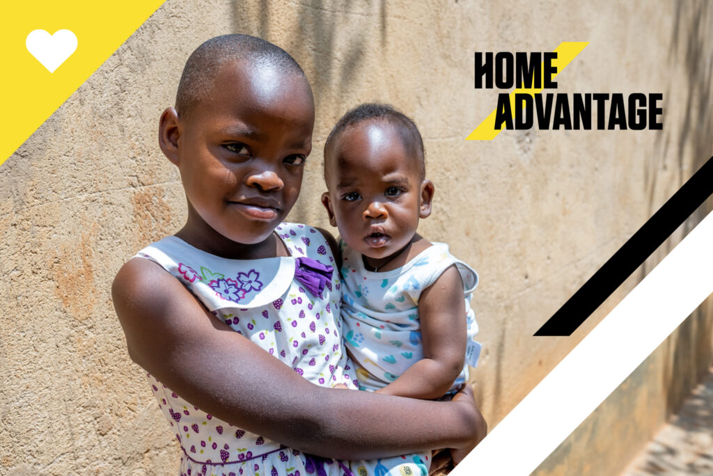 Uwase holds her little sister in her arms