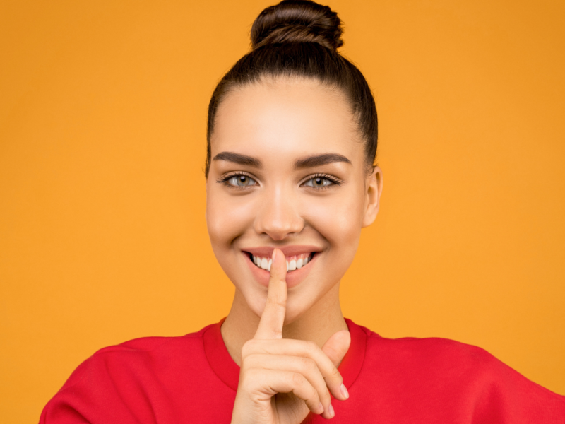 A woman with her finger on her lips doing a sponsored silence