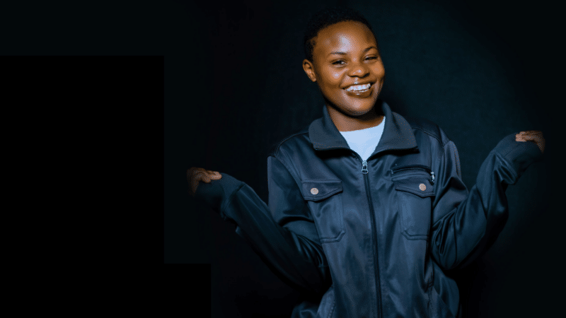 Ombi, a young woman from Rwanda, smiling proudly.